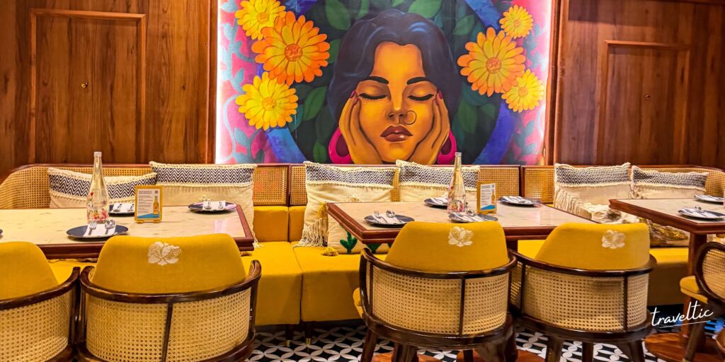 Jugnu restaurant’s pristine white indoor dining room with elegant arches, black and white geometric flooring, and botanical wall art